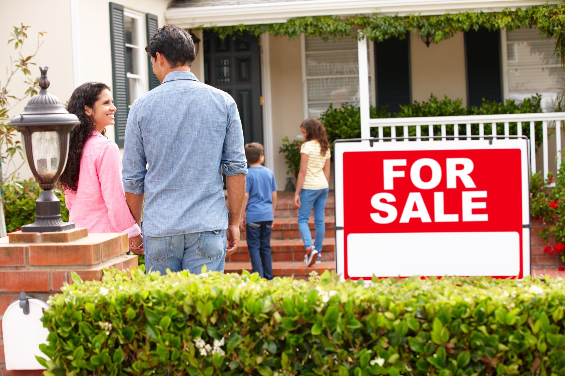 11217696 - hispanic family outside home with for sale sign